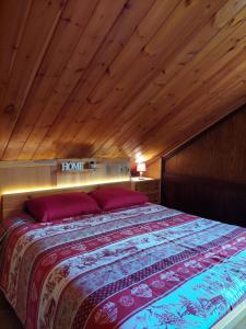 a bedroom with a large bed with a wooden ceiling at Philia Dolomiti, Folgarida in Folgarida