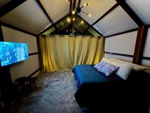 a bedroom with a bed and a tv in a room at Cabanas Saruê - Toca in Tarituba
