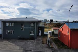 uma casa num parque de estacionamento ao lado de um edifício em The Stykkishólmur Inn by Ourhotels em Stykkishólmur