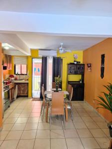 eine Küche mit einem Tisch und Stühlen sowie gelben Wänden in der Unterkunft Renovated apartment in Las Palmas in Coco