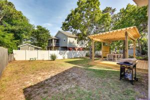 un patio trasero con una parrilla y una pérgola de madera en Oak Island Cottage Minutes to Long Beach!, en Oak Island