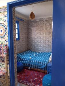 a bedroom with a bed in a room with a mirror at Studio Dar ziane in El Jadida +24 photos