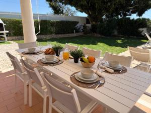 a wooden table with food and fruit on it at Casa Alves - Villa with private heated swimming pool in Olhos de Água