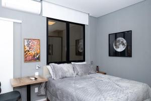 Un dormitorio con una cama y una ventana grande. en Guaja 745 - Apartamento Kiko, en Belo Horizonte