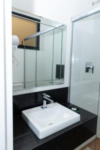Un baño con un lavabo blanco y un espejo. en Guaja 745 - Apartamento Kiko, en Belo Horizonte 6 fotos más