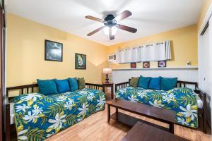 un soggiorno con 2 letti e un ventilatore a soffitto di Cozy 2br1ba AC Condo Kona Shores a Kailua-Kona Altre 23 foto