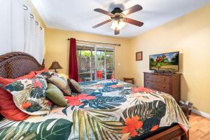 una camera da letto con un letto e un ventilatore a soffitto di Cozy 2br1ba AC Condo Kona Shores a Kailua-Kona
