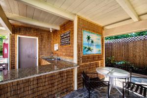 un ristorante con un bancone, un tavolo e delle sedie di Cozy 2br1ba AC Condo Kona Shores a Kailua-Kona