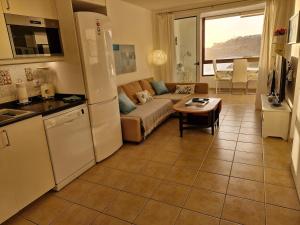 a kitchen and living room with a couch and a table at Patalavaca beach apartment with stunning ocean view in Patalavaca