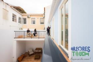 a group of people standing on the balcony of a building at Hostel Casa São Pedro - Suíte 2 in Angra do Heroísmo
