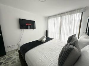 ペレイラにあるExcellent Location Ideal for Large Groupsの壁にテレビが付いたベッドのある寝室