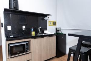 une cuisine avec un évier et un micro-ondes dans l'établissement Guaja - 745 - Amora Mel Apartamento, à Belo Horizonte