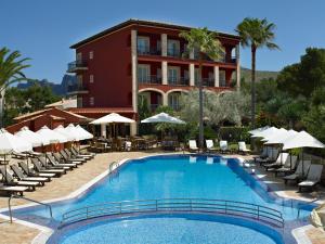 a pool at a hotel with chairs and umbrellas at Hotel Cala Sant Vicenç - Adults Only in Cala de Sant Vicenc