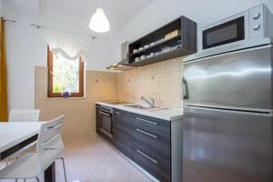 a kitchen with a stainless steel refrigerator and a sink at Istria Sea Side Apartments Lina in Labin +10 photos