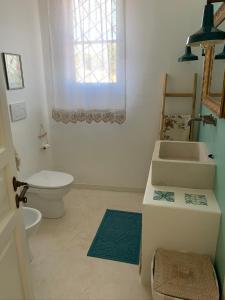 a bathroom with a sink and a toilet and a window at Casa Giardino in Sannicola