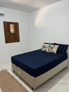 a bed in a white room with a blue mattress at CAJUÍ da VILA in Atins