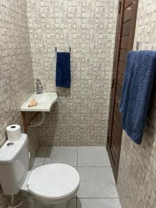 a bathroom with a white toilet and a sink at CAJUÍ da VILA in Atins