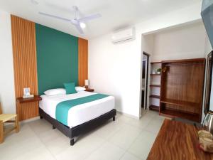 a bedroom with a bed and a green wall at Punta Colibrí in Brisas de Zicatela
