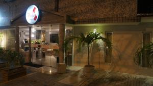 a restaurant with a palm tree in front of a building at Hotel Saveiro in Recife