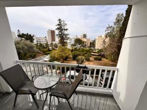 a balcony with a table and chairs and a view of a city at Limassol Beautiful Apartment II in Limassol