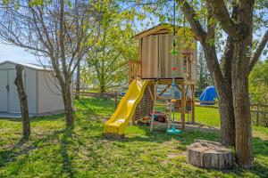 a playground with a tree house and a yellow slide at Okangan Sunset Bungalow in Vernon