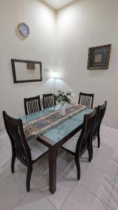 a dining room table with two chairs and a blue table at Musa Seri Iskandar Homestay in Seri Iskandar