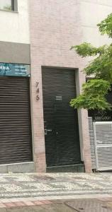 Dos puertas de garaje negras en un edificio con un cartel en Guaja 745 - Apartamento Tony, en Belo Horizonte