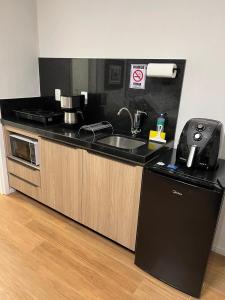 Una encimera de cocina con un fregadero y una cafetera. en Guaja 745 - Apartamento Tony, en Belo Horizonte