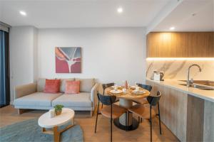 a kitchen and living room with a couch and a table at Star above, Ocean Beyond - Lv 43 Luxury Apartment with Panoramic View on The Star Casino Broadbeach in Gold Coast