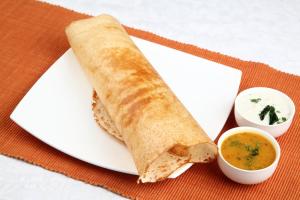 a white plate with a sandwich and a dipping sauce at Hotel O Black Pearl Residency in Pīlamedu +37 photos
