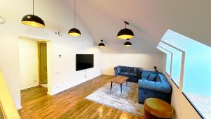 a living room with a blue couch and a tv at Casa Damadian in Constanţa
