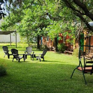 eine Gruppe von Stühlen und einem Tisch im Gras in der Unterkunft Bungalows Génesis ideal para las familias a 12 cuadras del parque termal in Federación + 2 Fotos