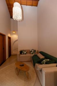 a living room with a couch and a table at Casa Floresta - Caminhos de OP in Ouro Preto
