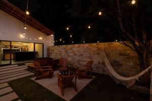 a patio with a table and chairs and a brick wall at Casa Floresta - Caminhos de OP in Ouro Preto