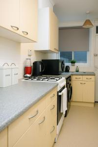 a kitchen with white cabinets and a stove top oven at Prospects Cottage in Dover