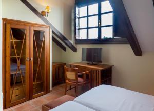 a bedroom with a bed and a desk with a television at Hotel The Island in La Isla