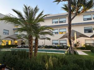 a building with two palm trees and a swimming pool at Casa Begonias Hotel mas Villas in Jiutepec
