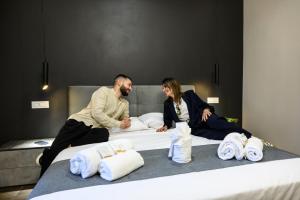 a man and woman sitting on a bed with towels at La Dimora del Re in Rome +44 photos