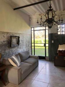 a living room with a couch and a chandelier at Los Rosales - Genuinamente Campo in Torres +12 photos