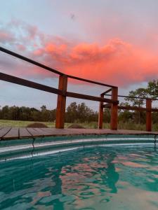 a swimming pool with a sunset in the background at Los Rosales - Genuinamente Campo in Torres