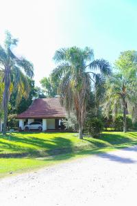 a house with palm trees and a car parked in front at Casa Quinta Los Molinos 1912 in Estación Las Flores