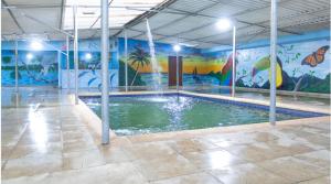 a swimming pool with a mural in a building at hotel casa martin in Gaira