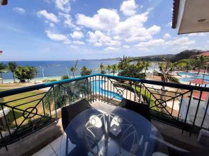 d'un balcon avec un parasol et une vue sur la plage. dans l'établissement Nasugbu Resort, Beachfront Condo in Canyon Cove A1-301, à Nasugbu