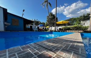 a swimming pool at a resort with a palm tree at Tunco Sun Room 2 in Tamanique