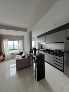 a kitchen and living room with a couch and a table at Apartamento Oliveira in Sinop
