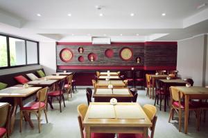 a dining room with tables and chairs and windows at Aruá Pousada Boutique in Torres