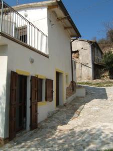 a white building with brown doors and a balcony at La Casetta di Zio Gino in Cingoli