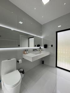 ein weißes Badezimmer mit Toilette und Waschbecken in der Unterkunft Casa de lujo con piscina en Malacatos in Loja