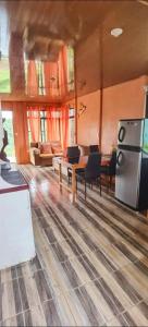 a living room with a refrigerator and tables and chairs at Paradise view apartment Drake Bay in Drake