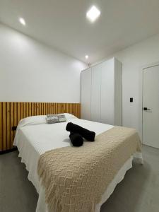 ein Schlafzimmer mit einem großen Bett und einem schwarzen Handtuch darauf in der Unterkunft Casa de lujo con piscina en Malacatos in Loja